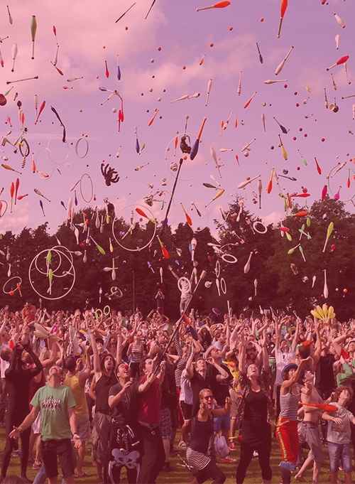 Crowd throwing juggling objects in air