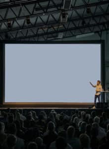 person presenting in front of large crowd