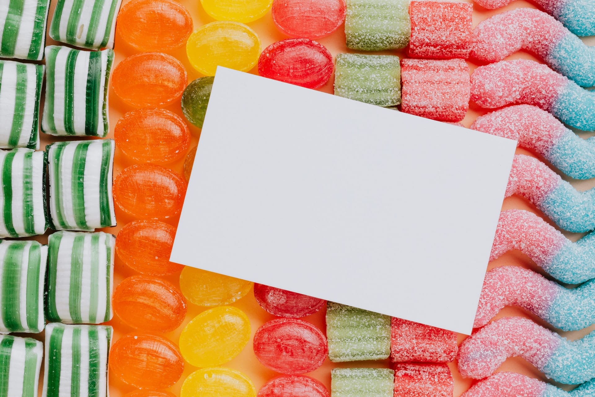 Photo by Karolina Grabowska: https://www.pexels.com/photo/empty-paper-placed-on-various-multicolored-candies-in-rows-4016508/